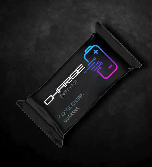 „Charge Riegel Cocos Cherry mit saftigen Kirschen und cremiger Kokosnuss, umhüllt von Kokosflocken und Reispuffs. Das Natursnack-Produkt zeigt die natürlichen Zutaten wie getrocknete Sauerkirschen, Kokosmehl, Kokosmilchpulver, Kakaomasse, Guaranaextrakt und Vanille-Aroma.“