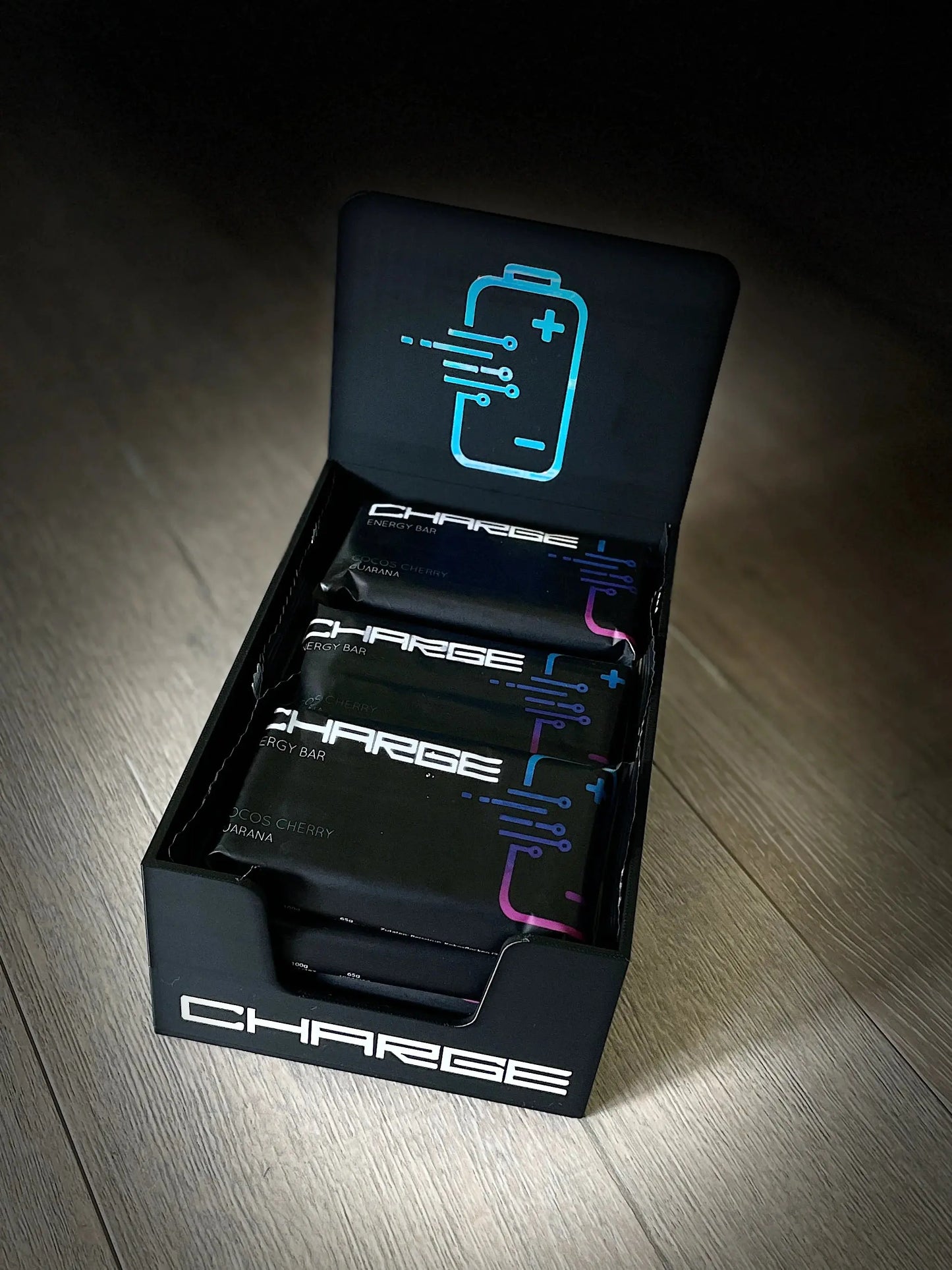 „Charge Riegel Cocos Cherry mit saftigen Kirschen und cremiger Kokosnuss, umhüllt von Kokosflocken und Reispuffs. Das Natursnack-Produkt zeigt die natürlichen Zutaten wie getrocknete Sauerkirschen, Kokosmehl, Kokosmilchpulver, Kakaomasse, Guaranaextrakt und Vanille-Aroma.“