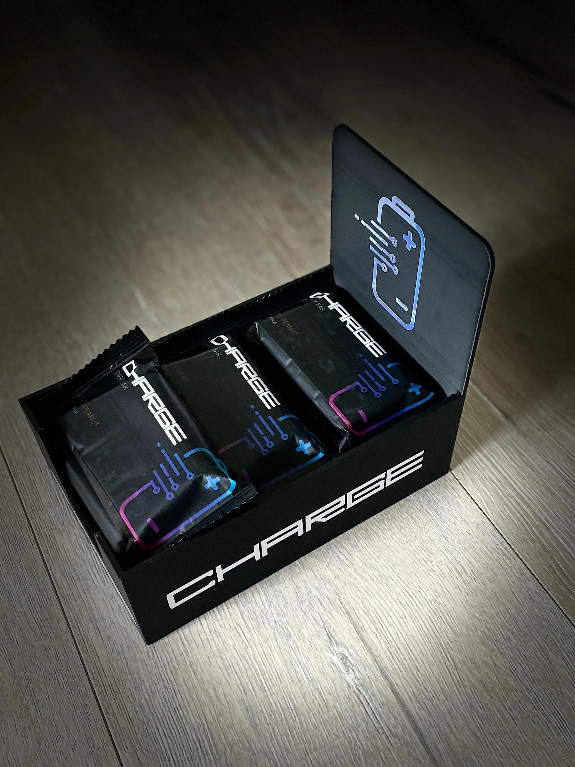 Das Bild zeigt einen Charge Riegel Choco Peanut, der mit seinen knusprigen Erdnüssen und dem edlen Kakao ein köstliches Schokoladenerlebnis verspricht. Der Riegel ist in einem attraktiven Verpackungsdesign präsentiert, das die hochwertigen Zutaten wie geröstete Erdnüsse, Kakaomasse, Kakaopulver und Mandelprotein hervorhebt.